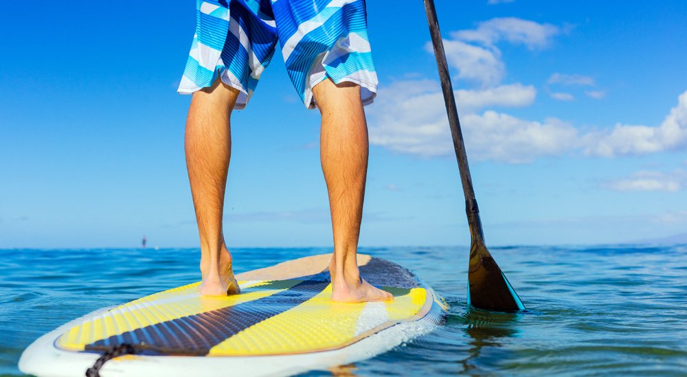 mans legs on stand up paddle board