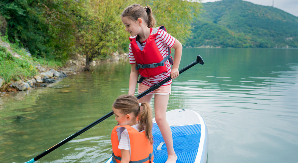 two girls learning stand up paddleboards